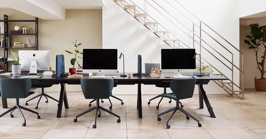 Office furniture Scotland: the VWork table with dividers so that each person has a more private space. At each section are an office chair with either a laptop or iMac computer. 