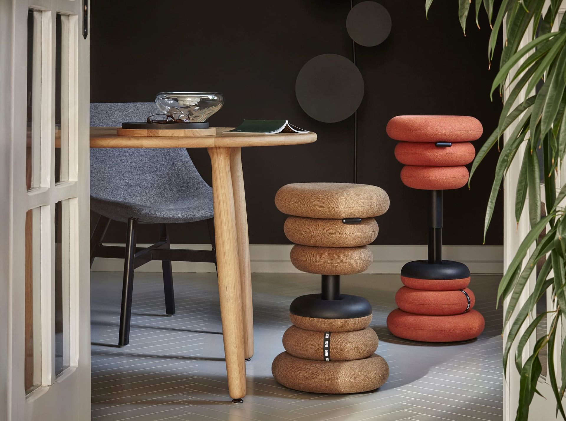 Cork stools in a dining room; table and chair are visible. One stool is orange, others are brown.