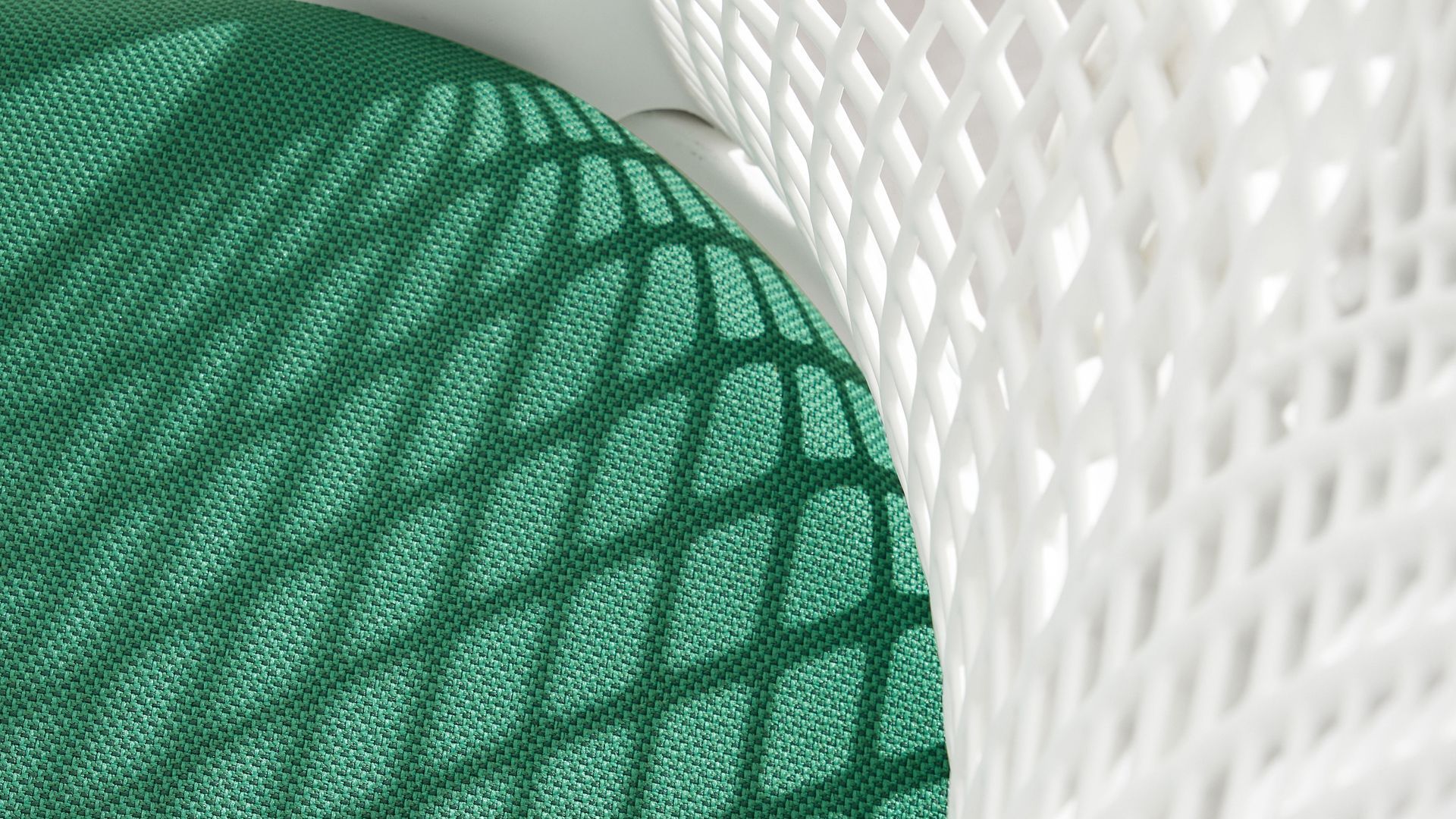 Close up view of the green seat on the RePlay Zero chair by Carmira with a white backrest. 