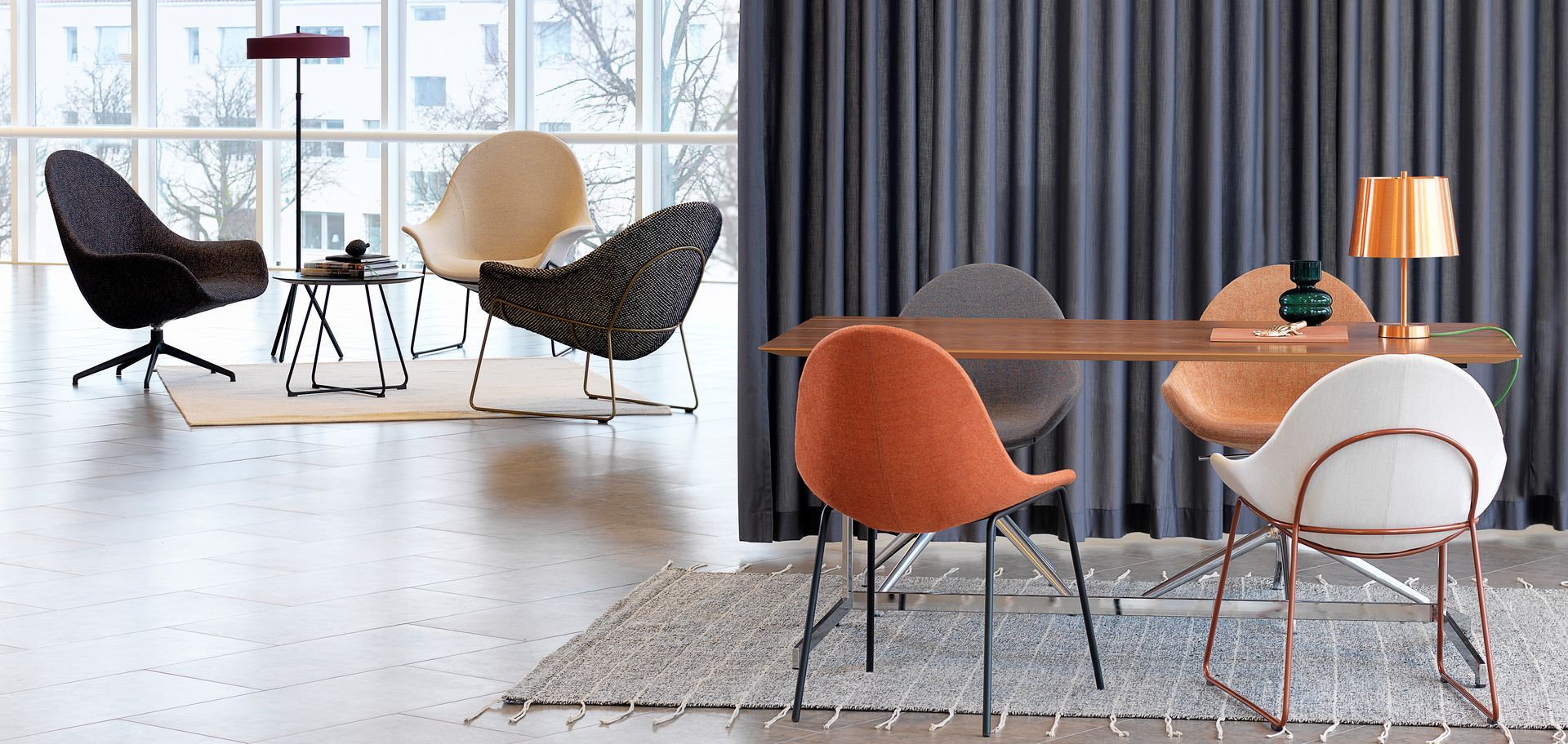 Modern interior with designer chairs, table, lamps, and rug in a bright room.