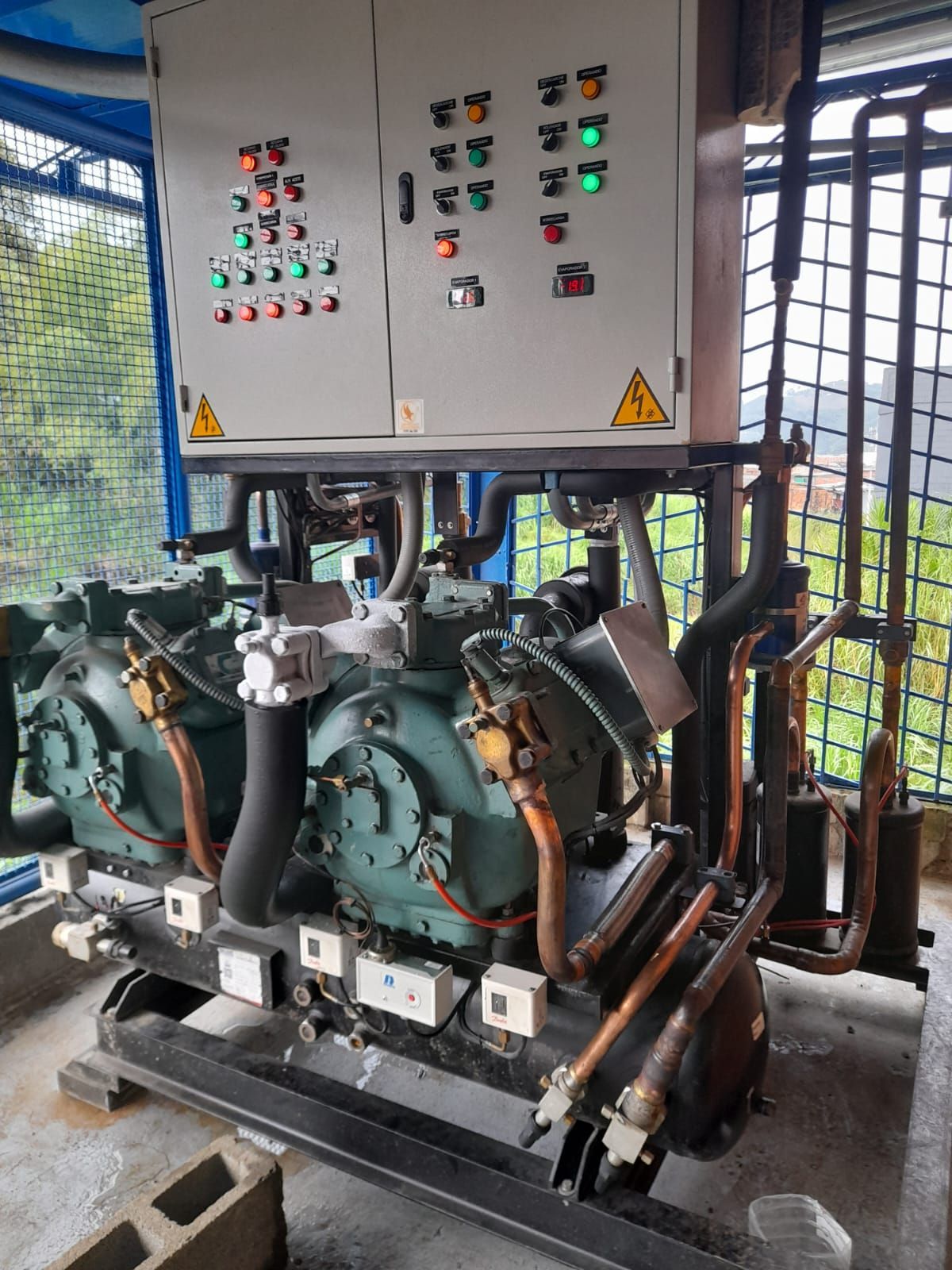 Unidad de refrigeración industrial con panel de control, tuberías y componentes eléctricos.