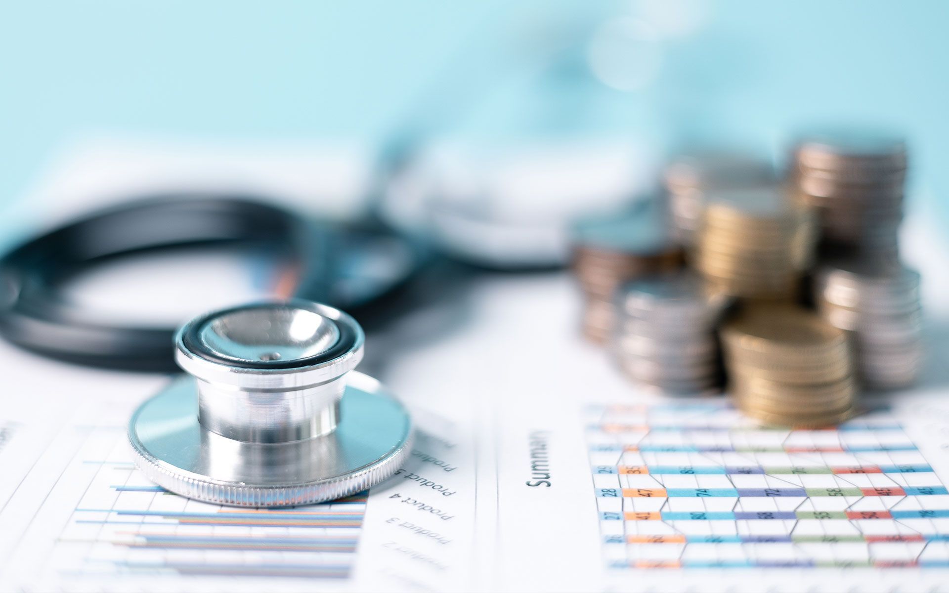 A stethoscope is sitting on top of a table next to a pile of coins.