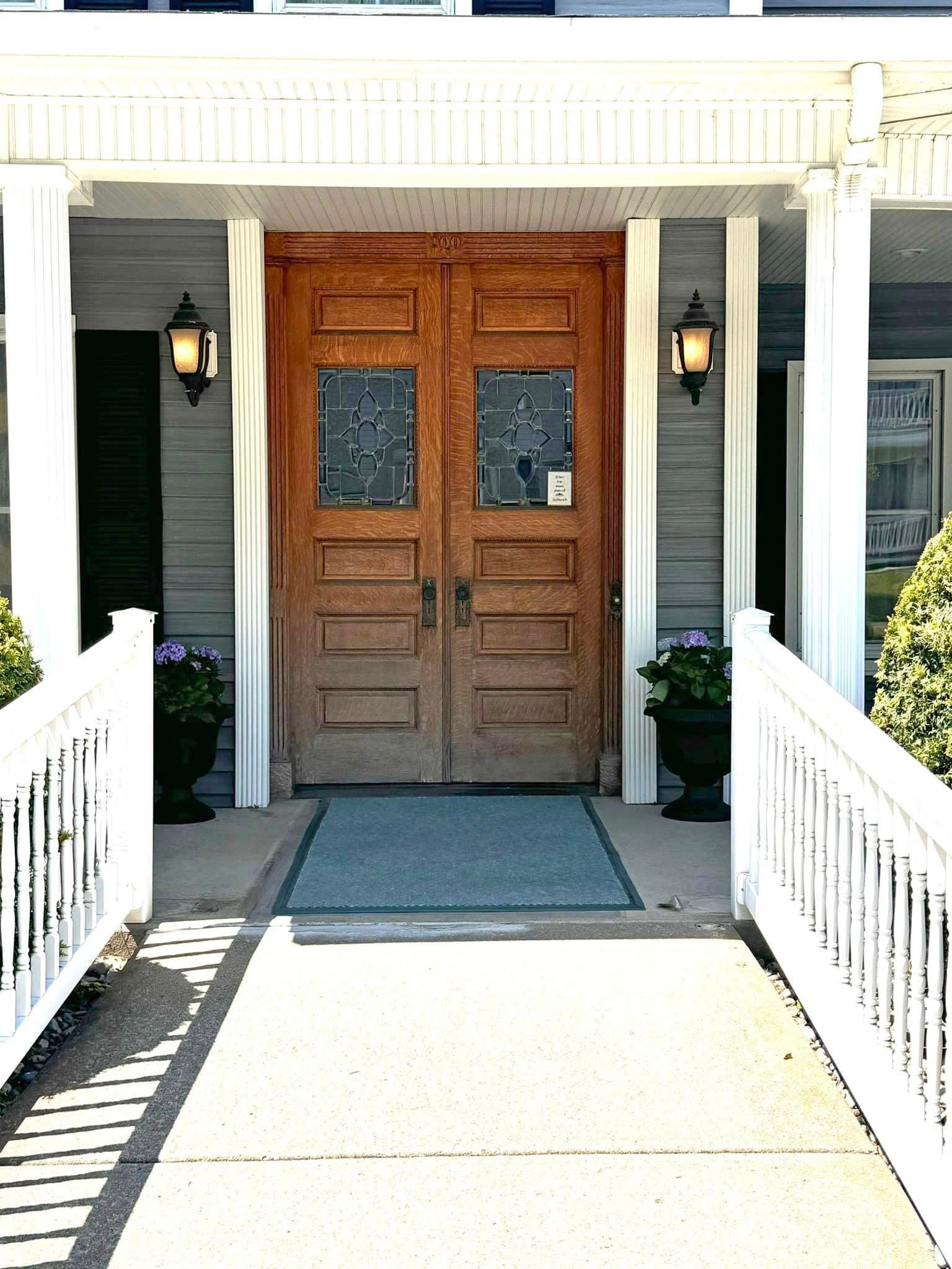 The front door of a house with a white railing