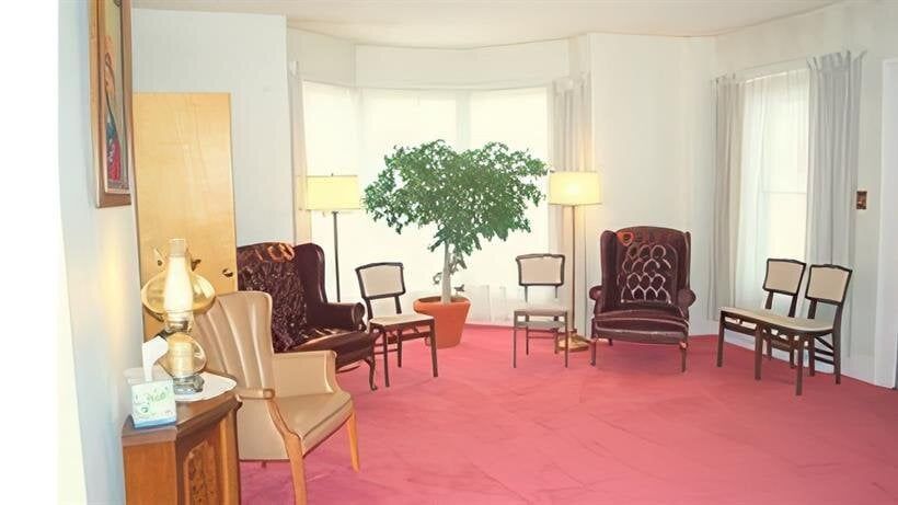 A living room with a pink carpet and chairs