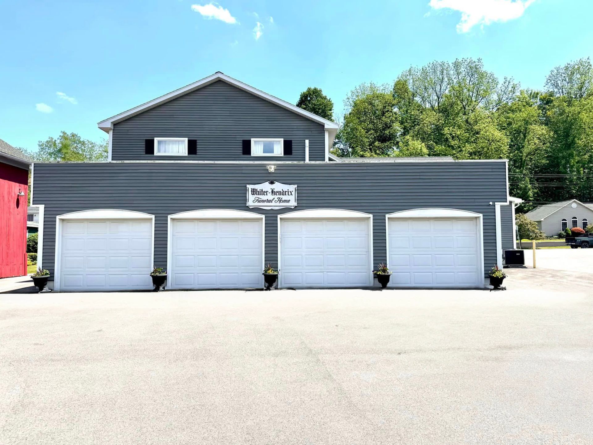 A row of garage doors are lined up in front of a house.
