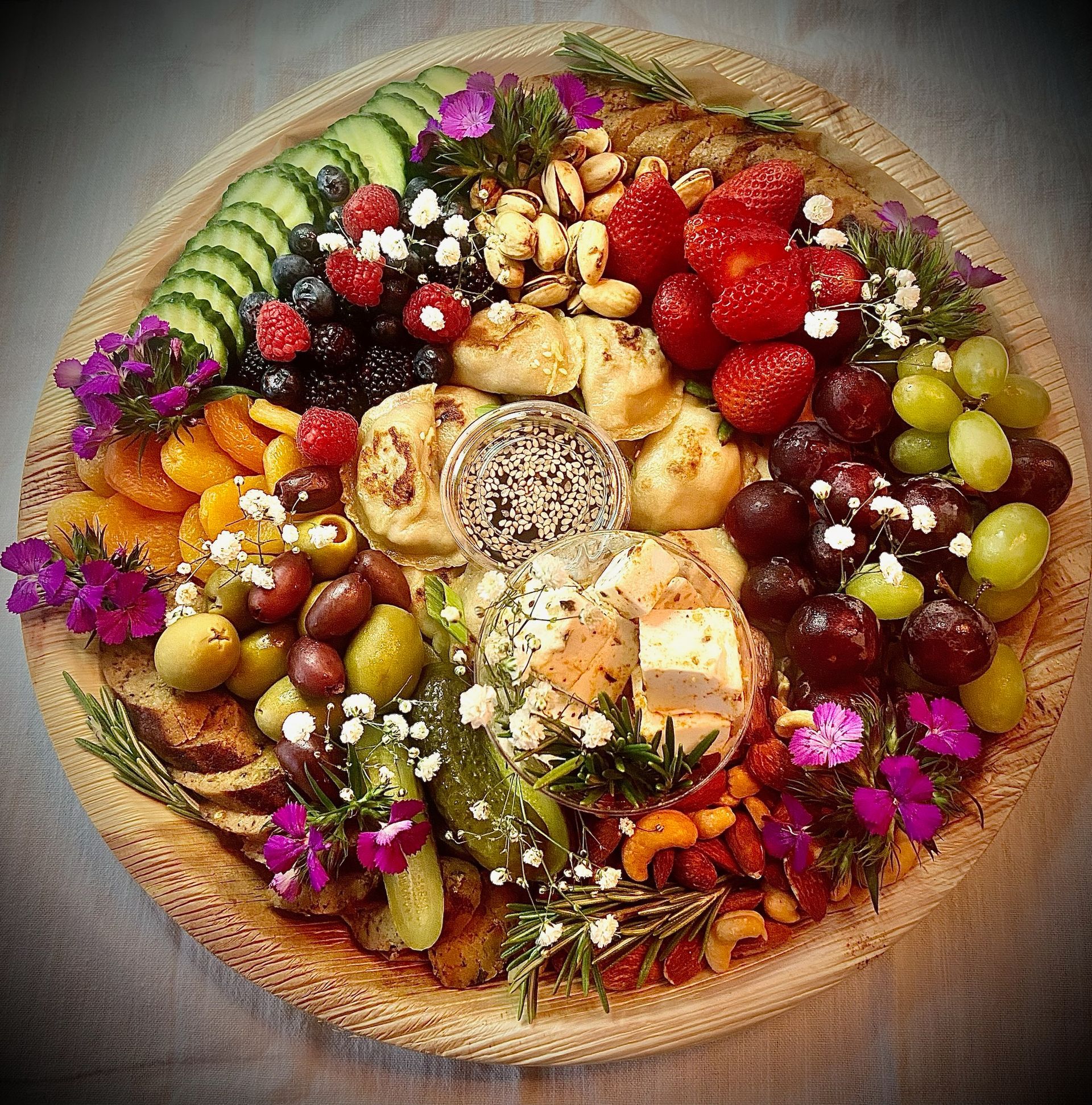 A wooden plate topped with a variety of fruits and vegetables.