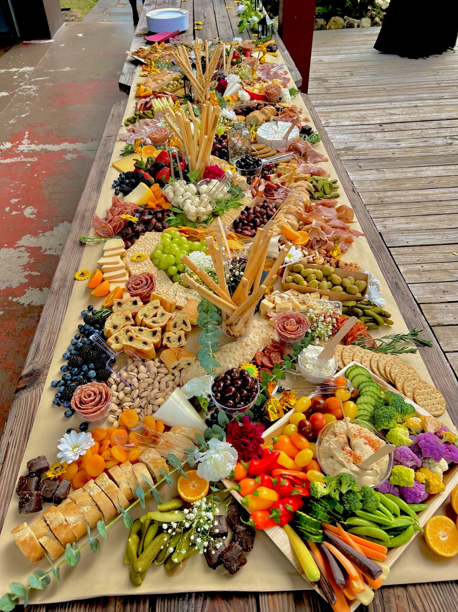 A long wooden table topped with a variety of fruits and vegetables.