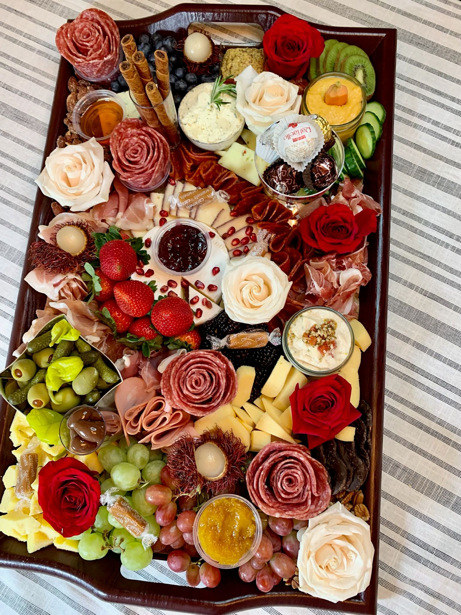 A large tray filled with lots of food and flowers on a table.