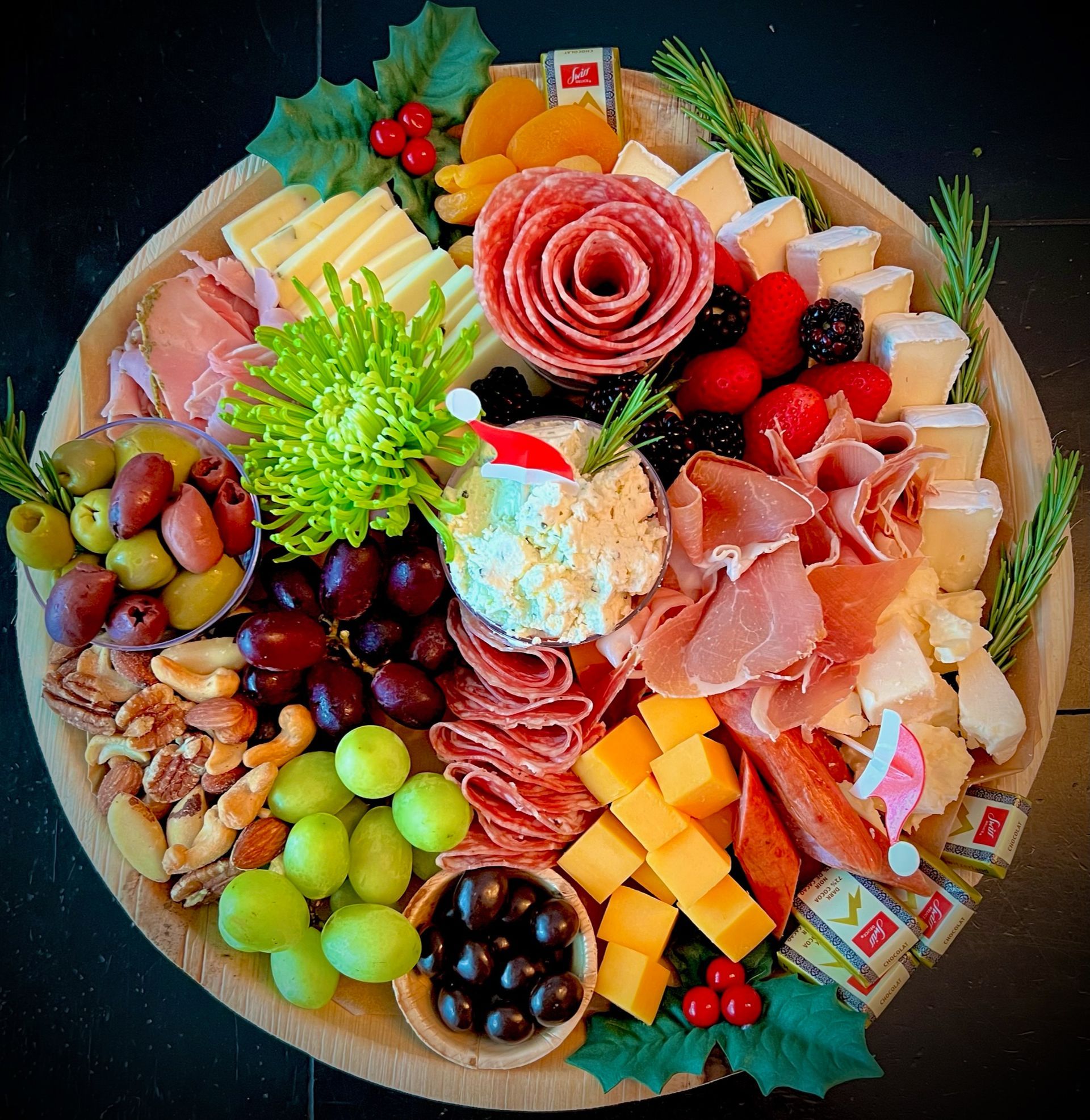 A wooden tray filled with a variety of meats and cheeses