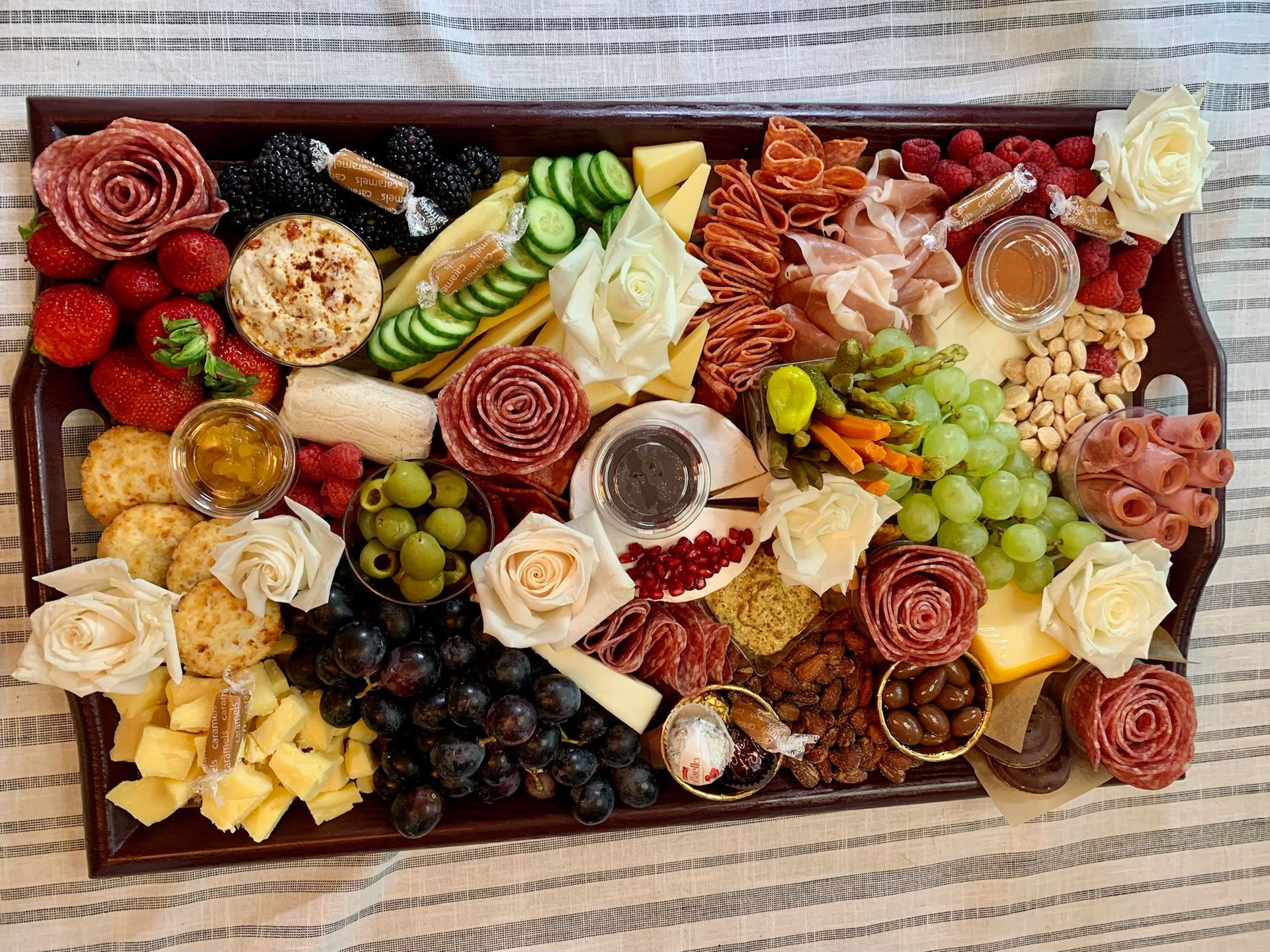 A large tray filled with lots of different types of food is sitting on a table.