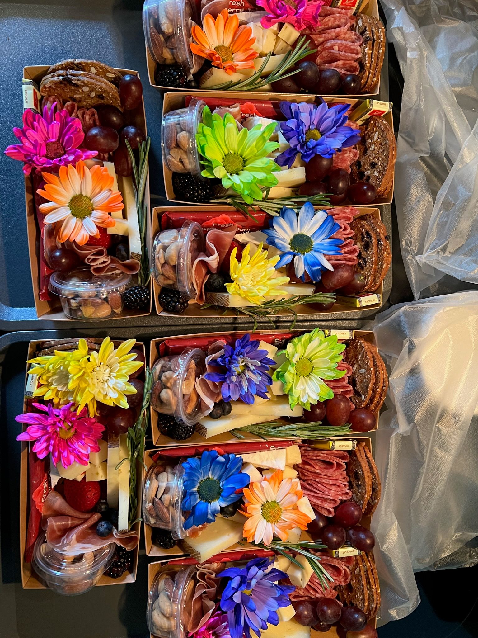 A bunch of boxes filled with food and flowers on a table.