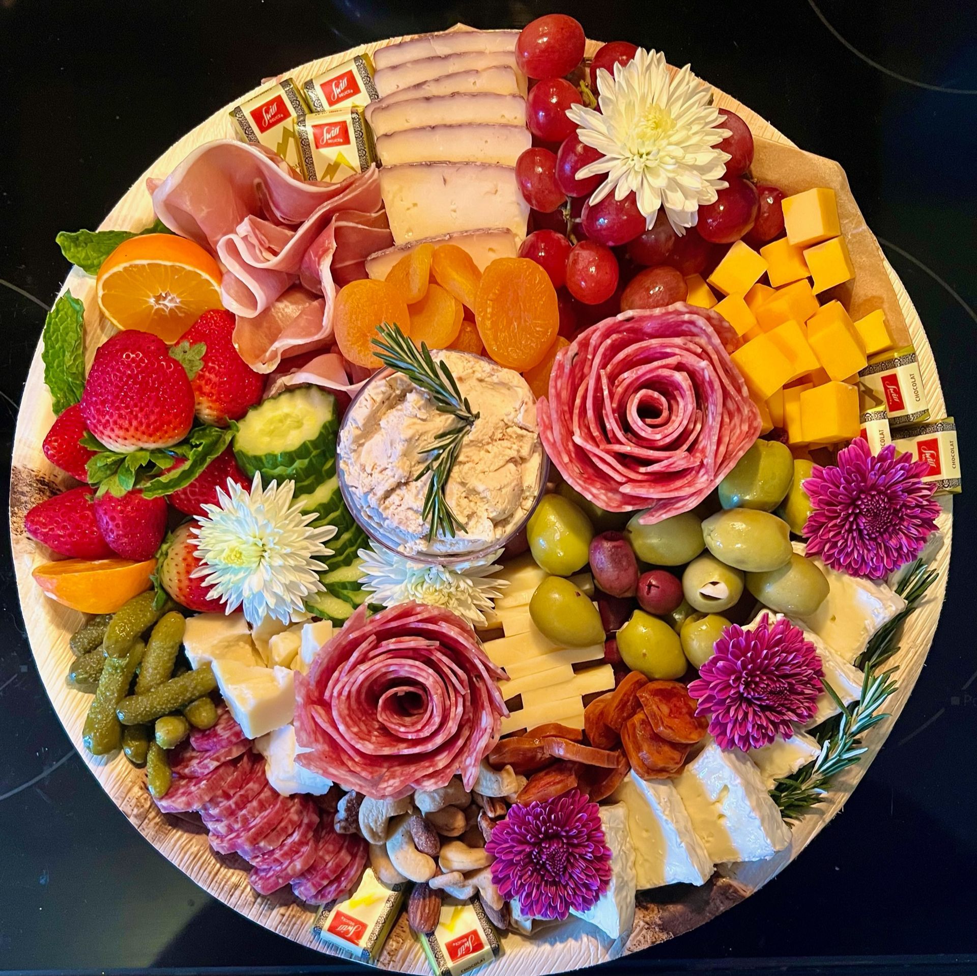 A plate of food with flowers and fruit on it
