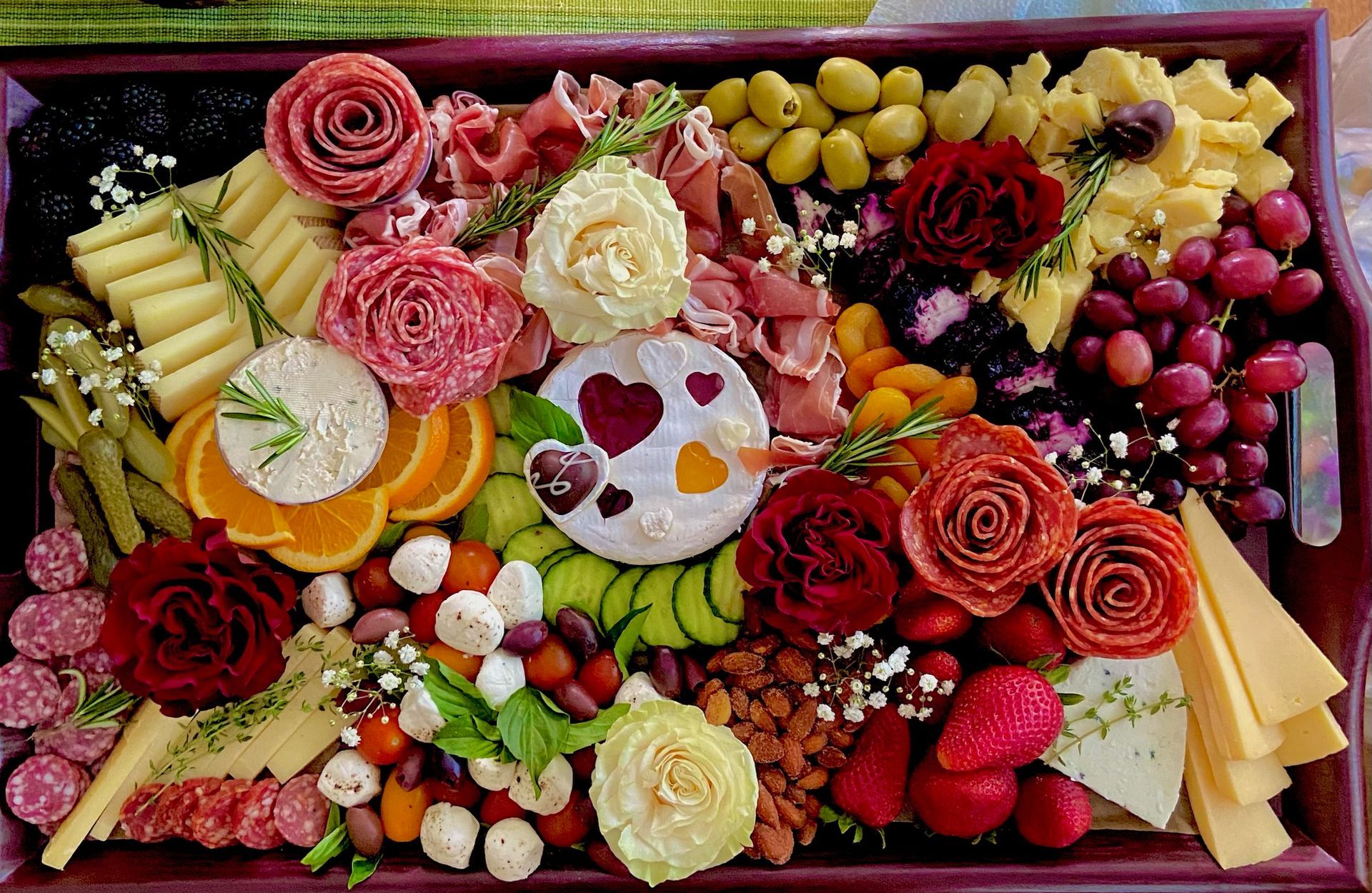 A tray filled with lots of different types of food and flowers.