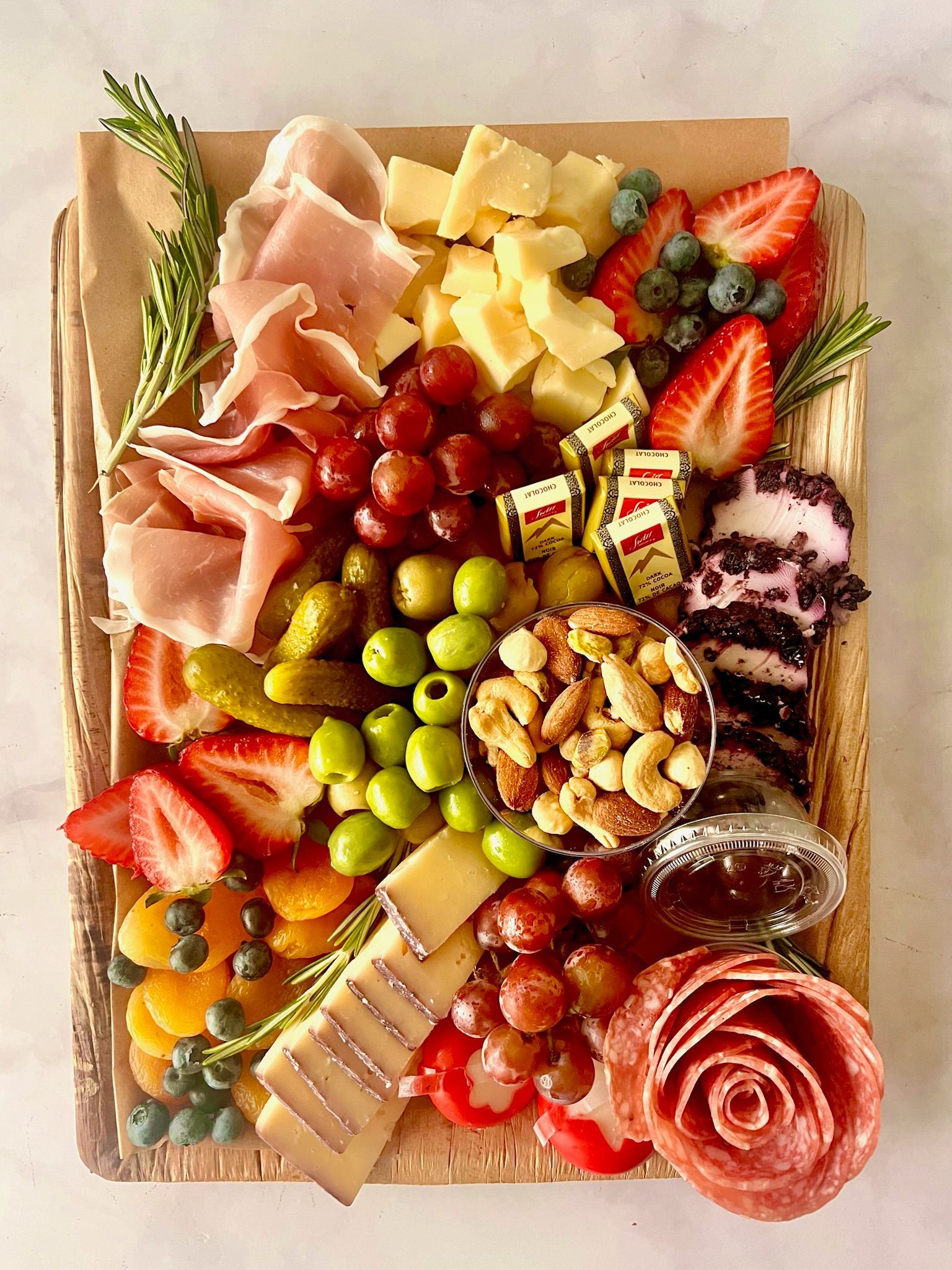 A wooden cutting board filled with lots of different types of food.