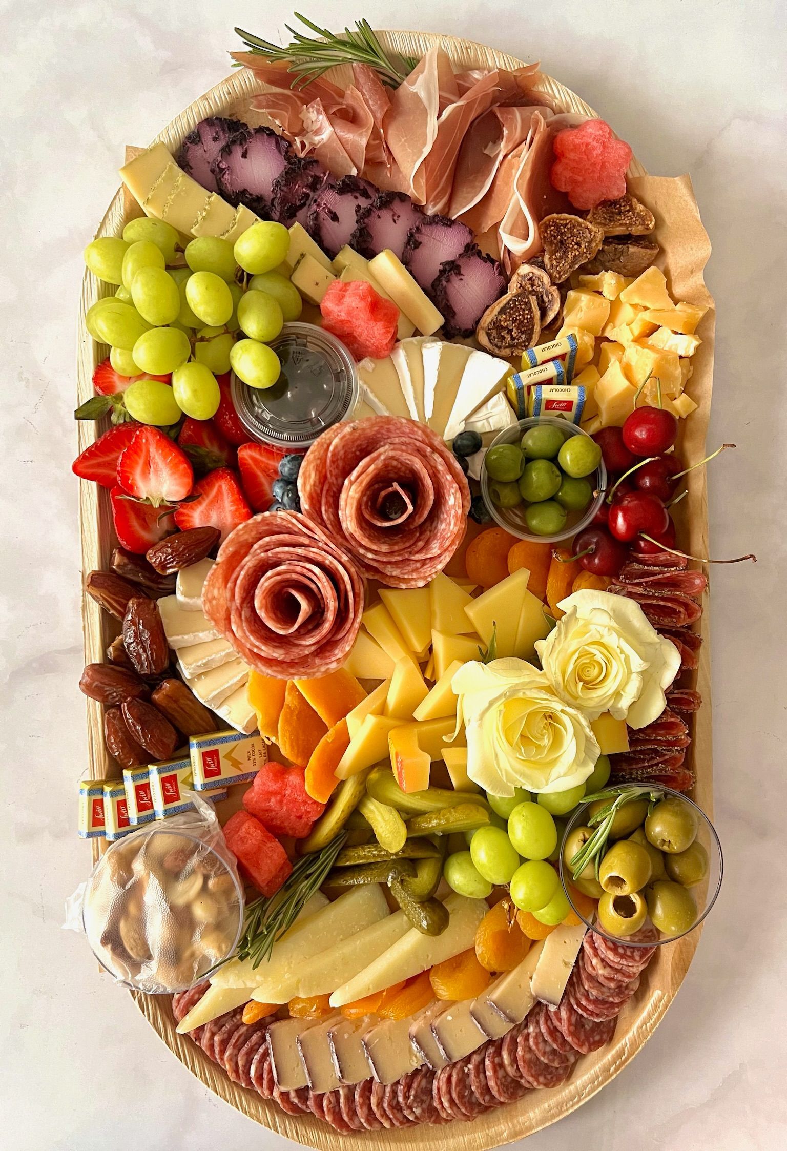 A wooden tray filled with lots of different types of food.