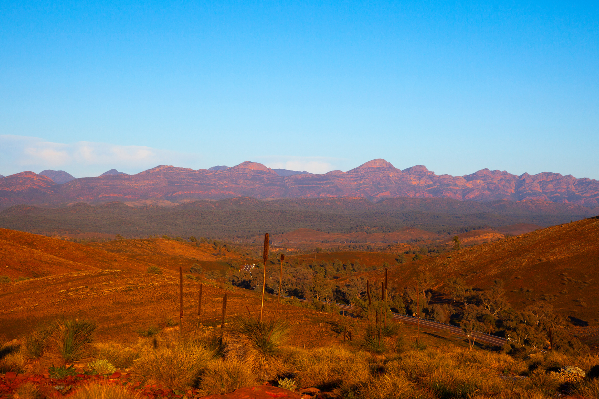 A desert landscape with mountains in the background and a blue sky
