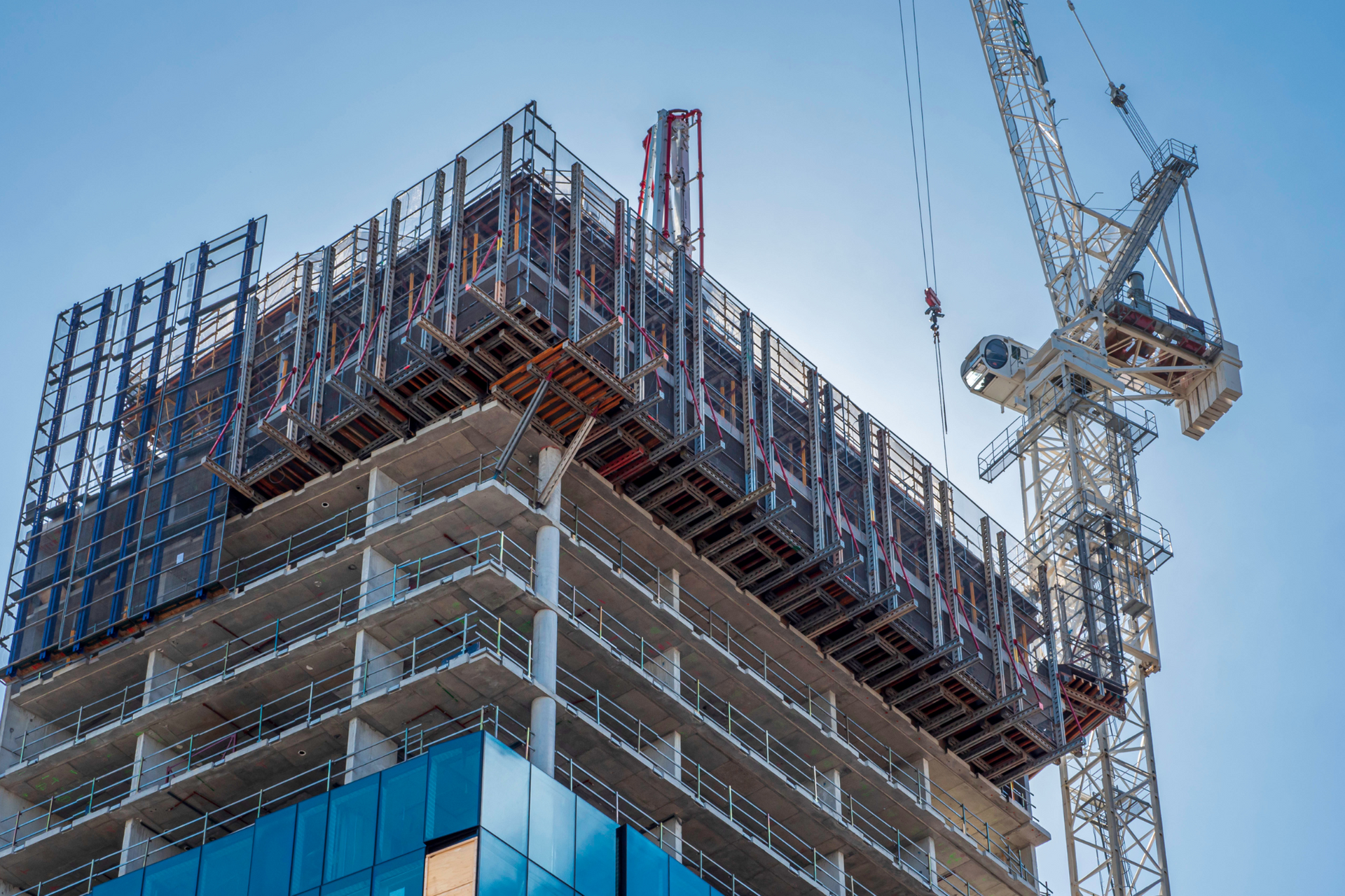 A tall building is being built with a crane in the background.