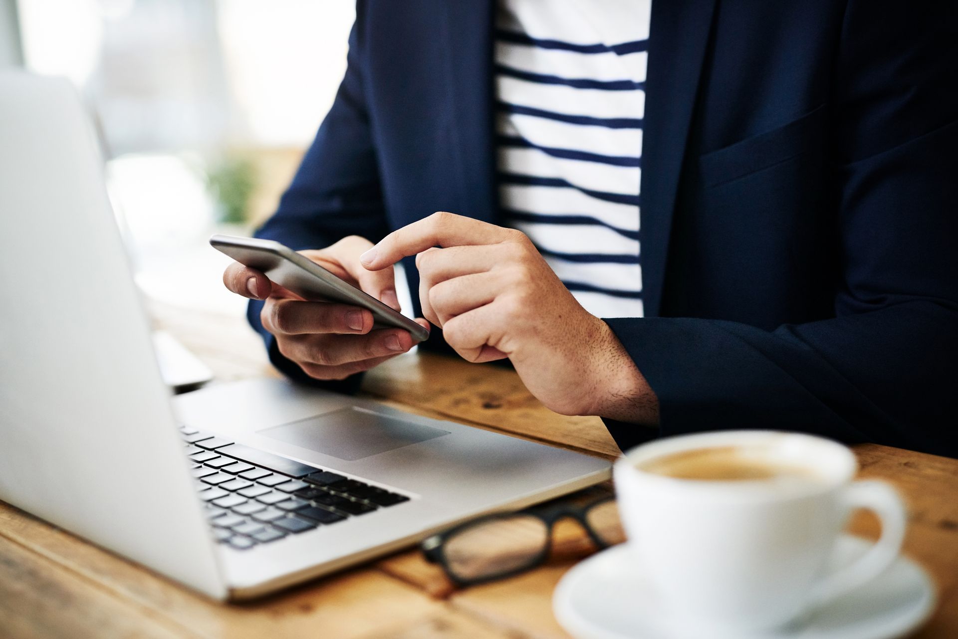 A man is sitting at a desk with a laptop and a tablet.