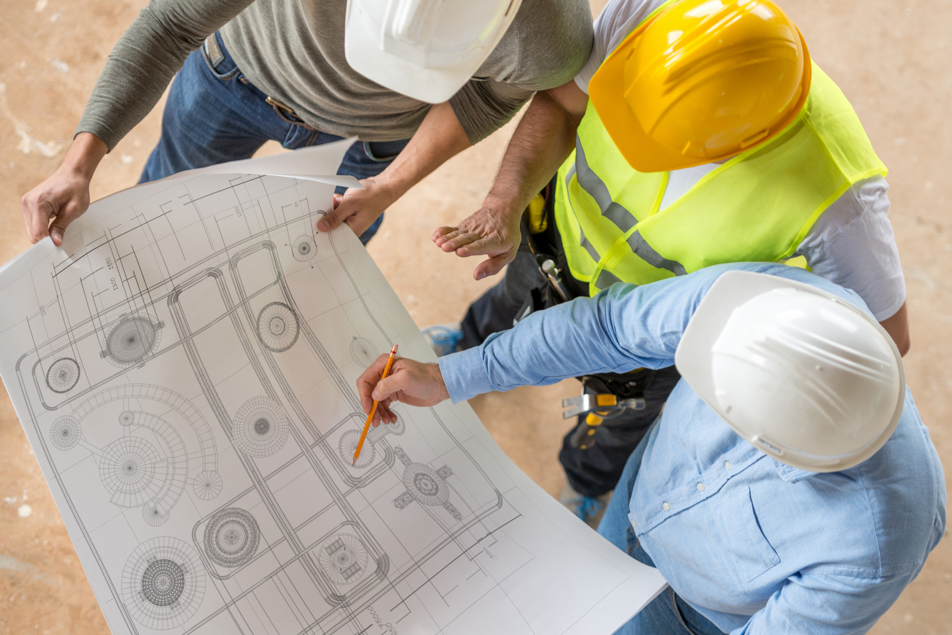 A group of construction workers are looking at a blueprint.