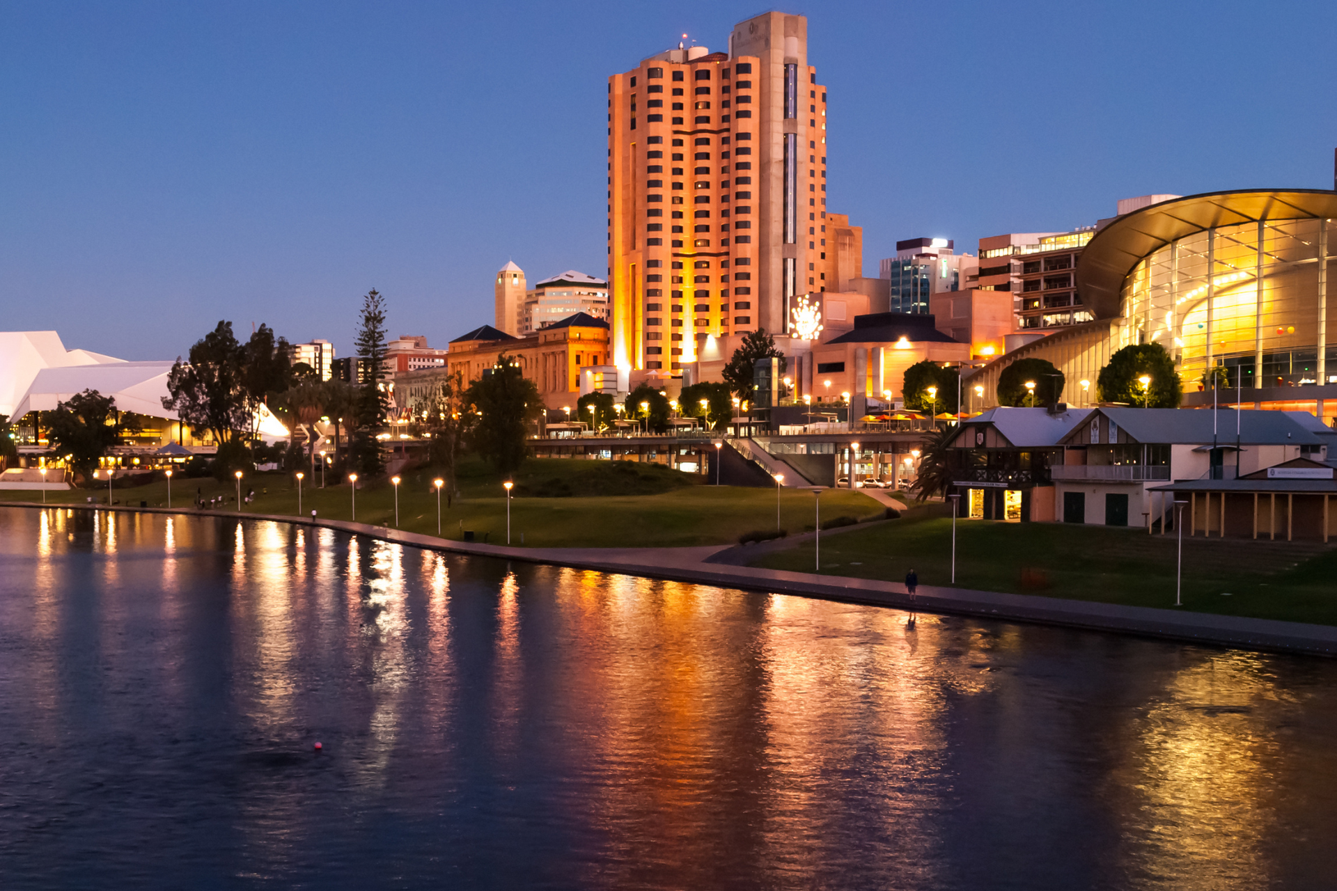 A city at night with a large body of water in the foreground