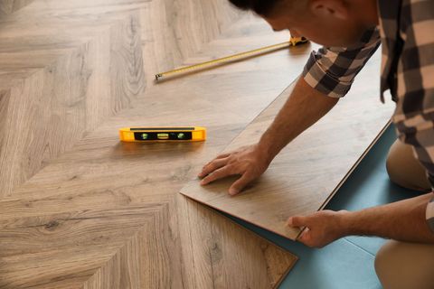 a man is installing a wooden floor in a room