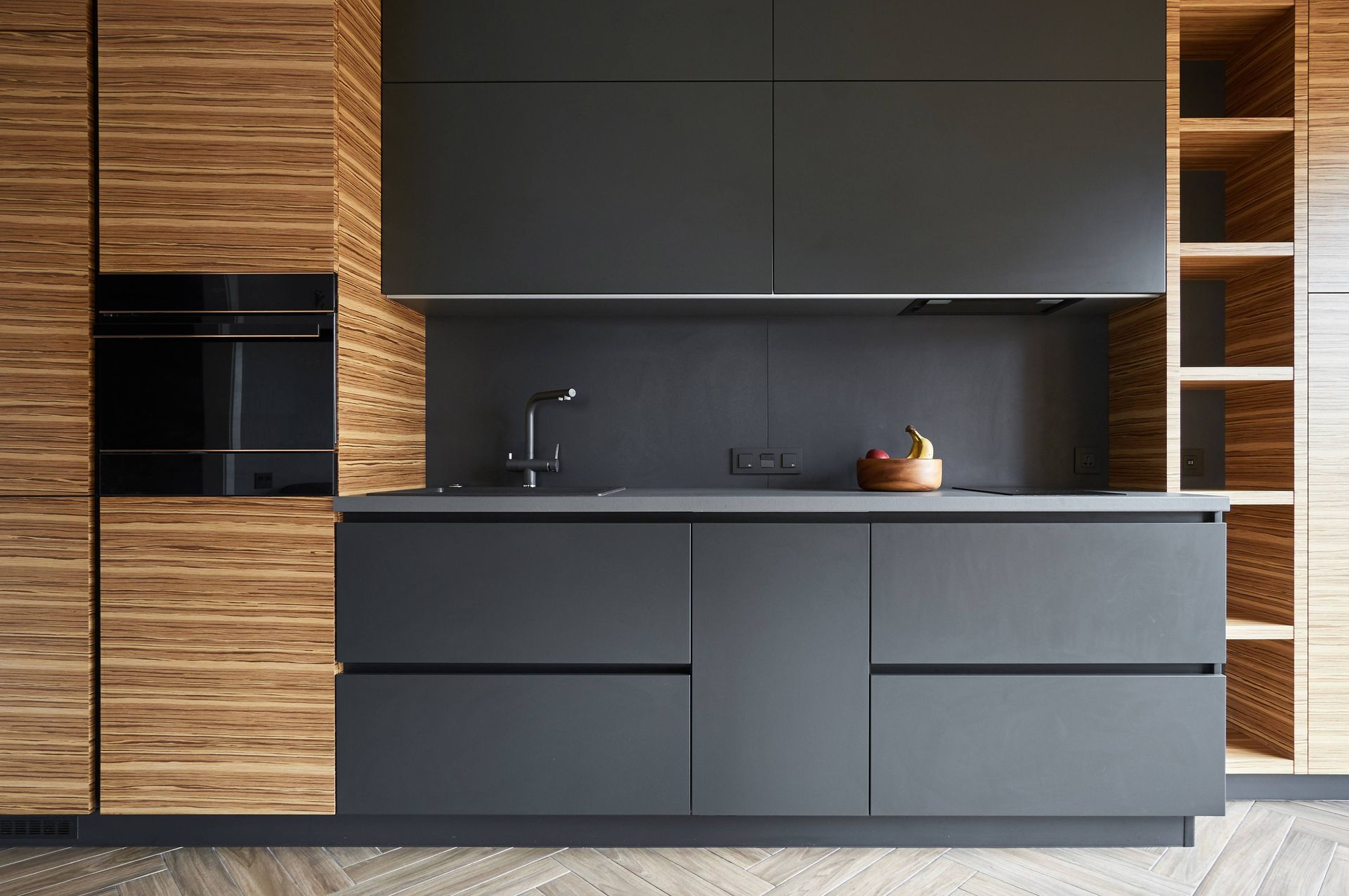 a kitchen with black cabinets and wooden cabinets
