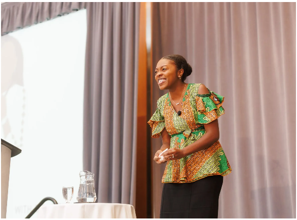 Dr. Chika Stacy Oriuwa standing in front of a podium