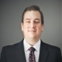 A man in a suit and tie is smiling for the camera.