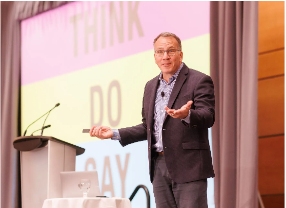 Ron Tite, CEO of Church + State giving a presentation in front of a large screen that says think do say