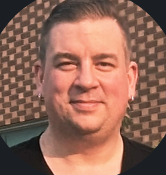 A man in a suit and tie is smiling for the camera.