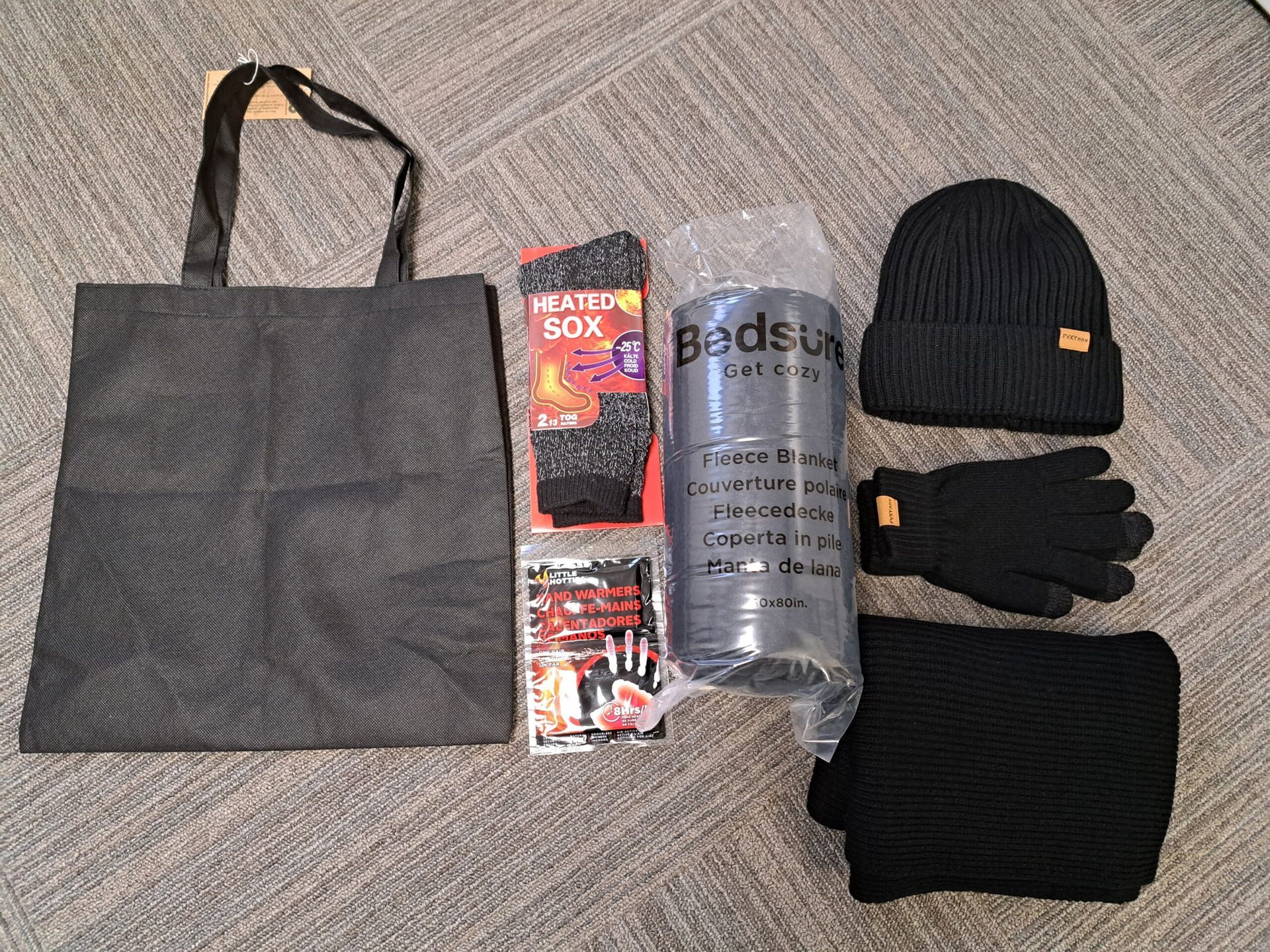 A black tote bag with a hat scarf and gloves on it