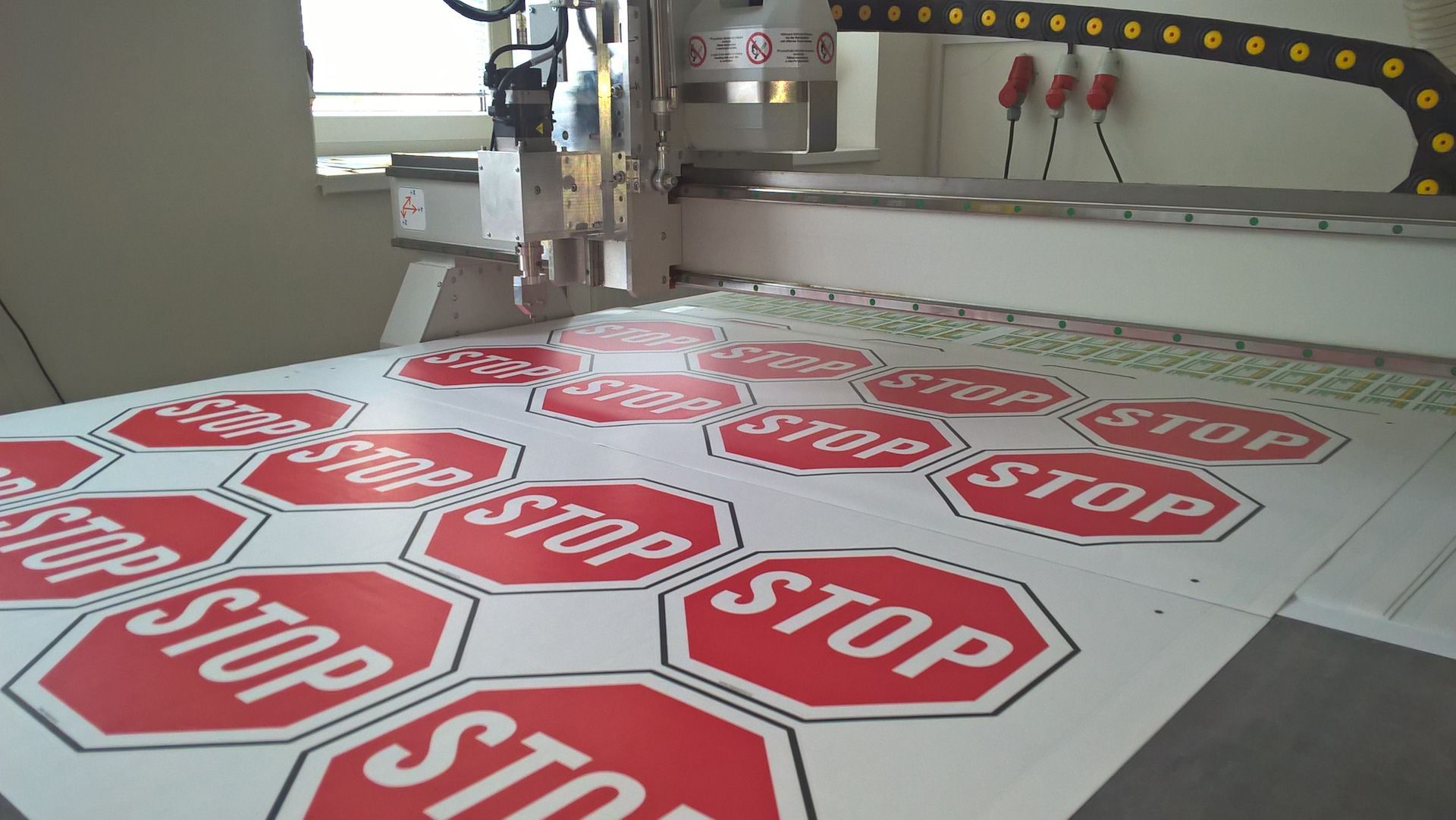 A stop sign is being cut on a machine