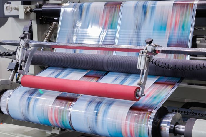 A printing machine is printing a sheet of paper on a roll.