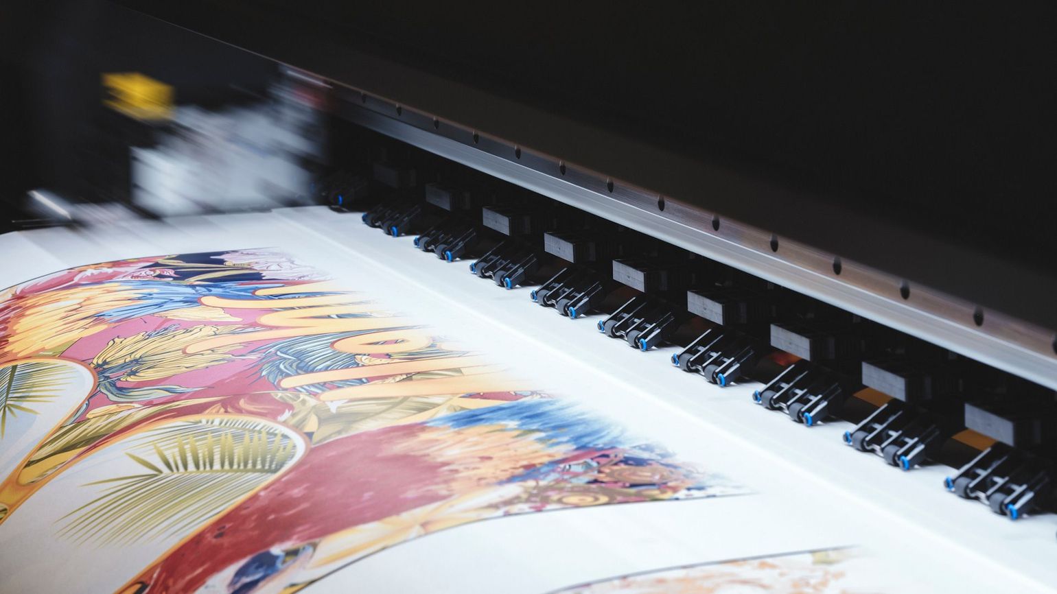 A large printer is printing a picture of a bird on a piece of paper.