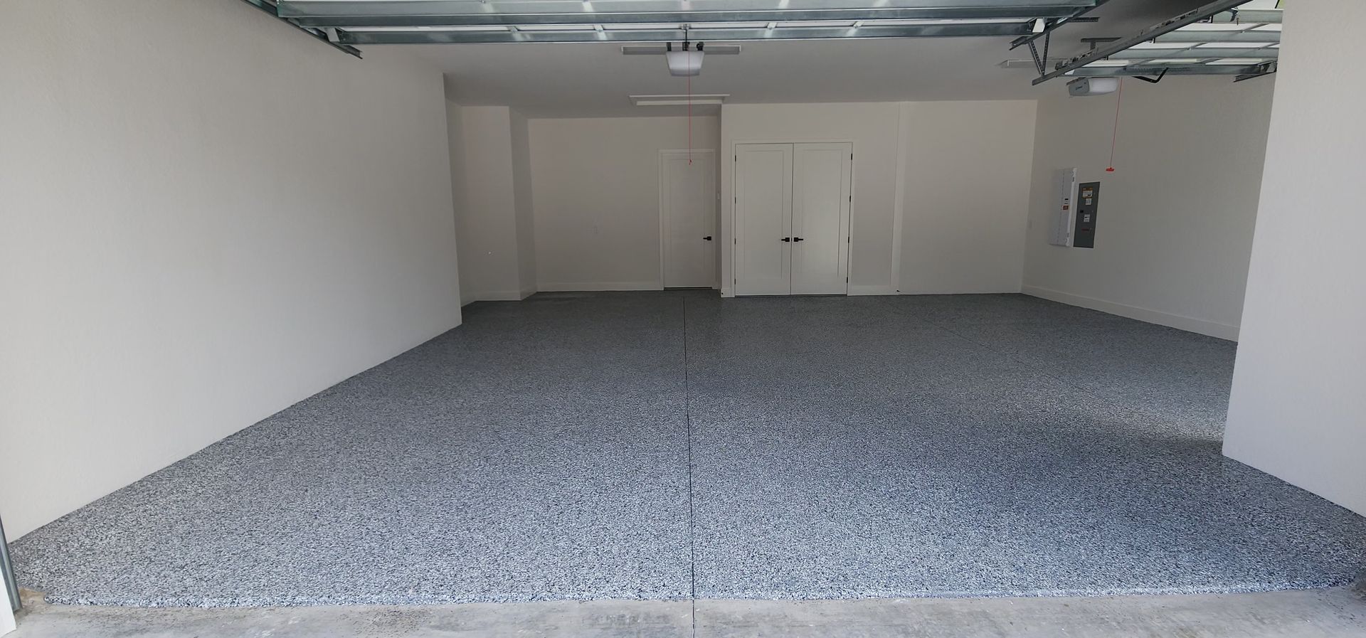 An empty garage with a blue tarp covering the door