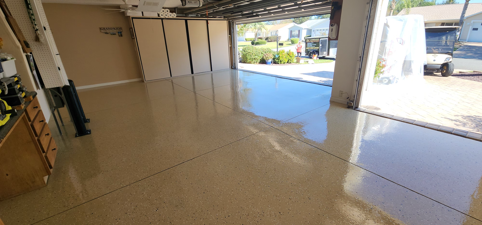 Garage with a glossy, speckled floor, open to the outside.