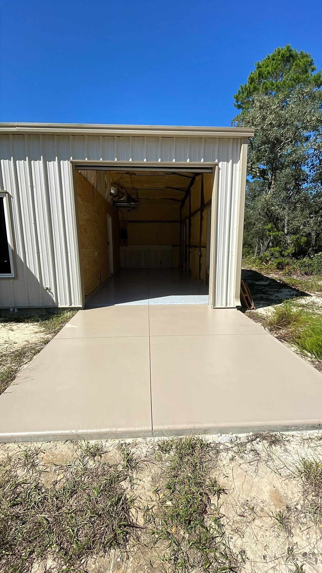 A garage with a concrete driveway leading to it.