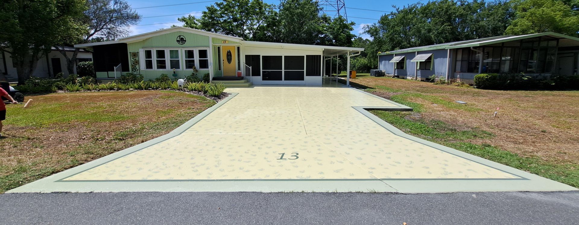 A driveway leading to a mobile home in a residential area.