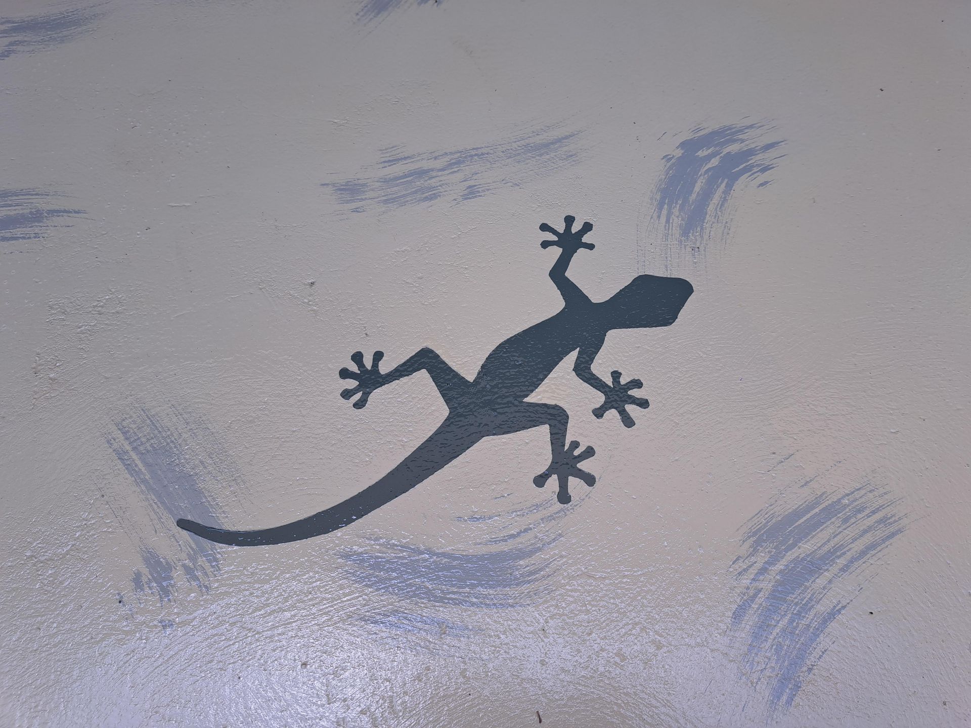 A silhouette of a lizard is painted on a wall