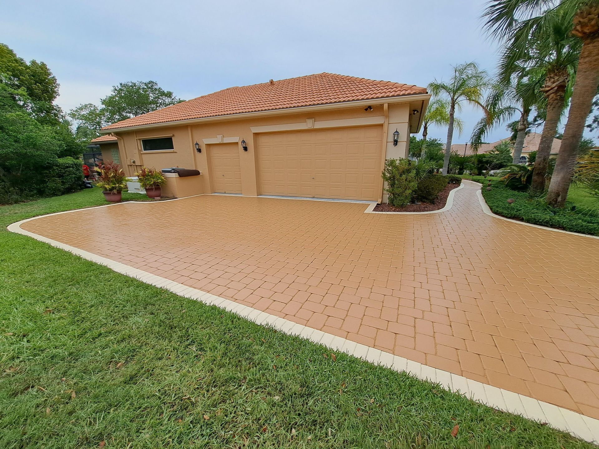 A brick driveway leading to a house with a garage