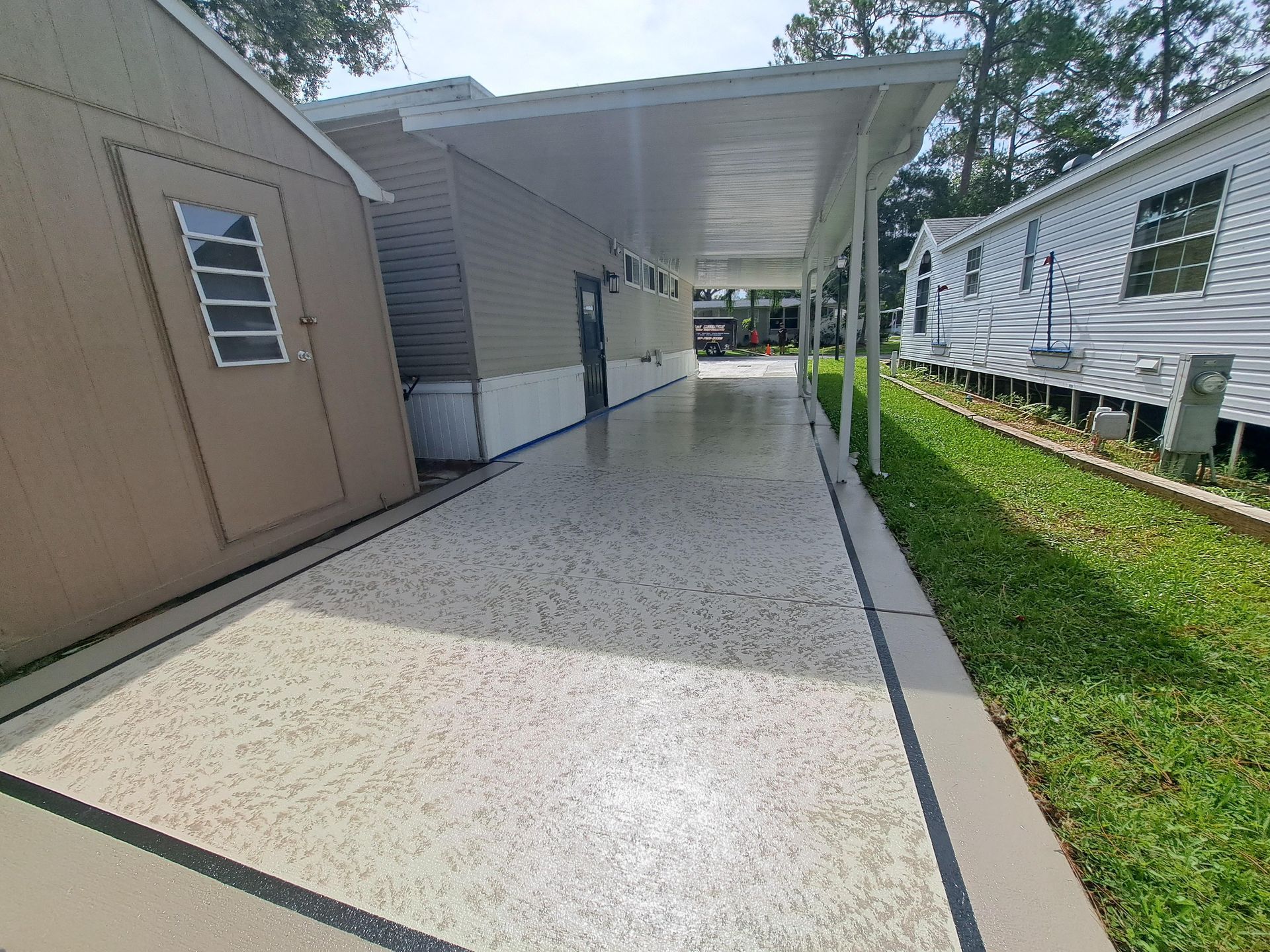 A long walkway leading to a mobile home with a covered walkway.