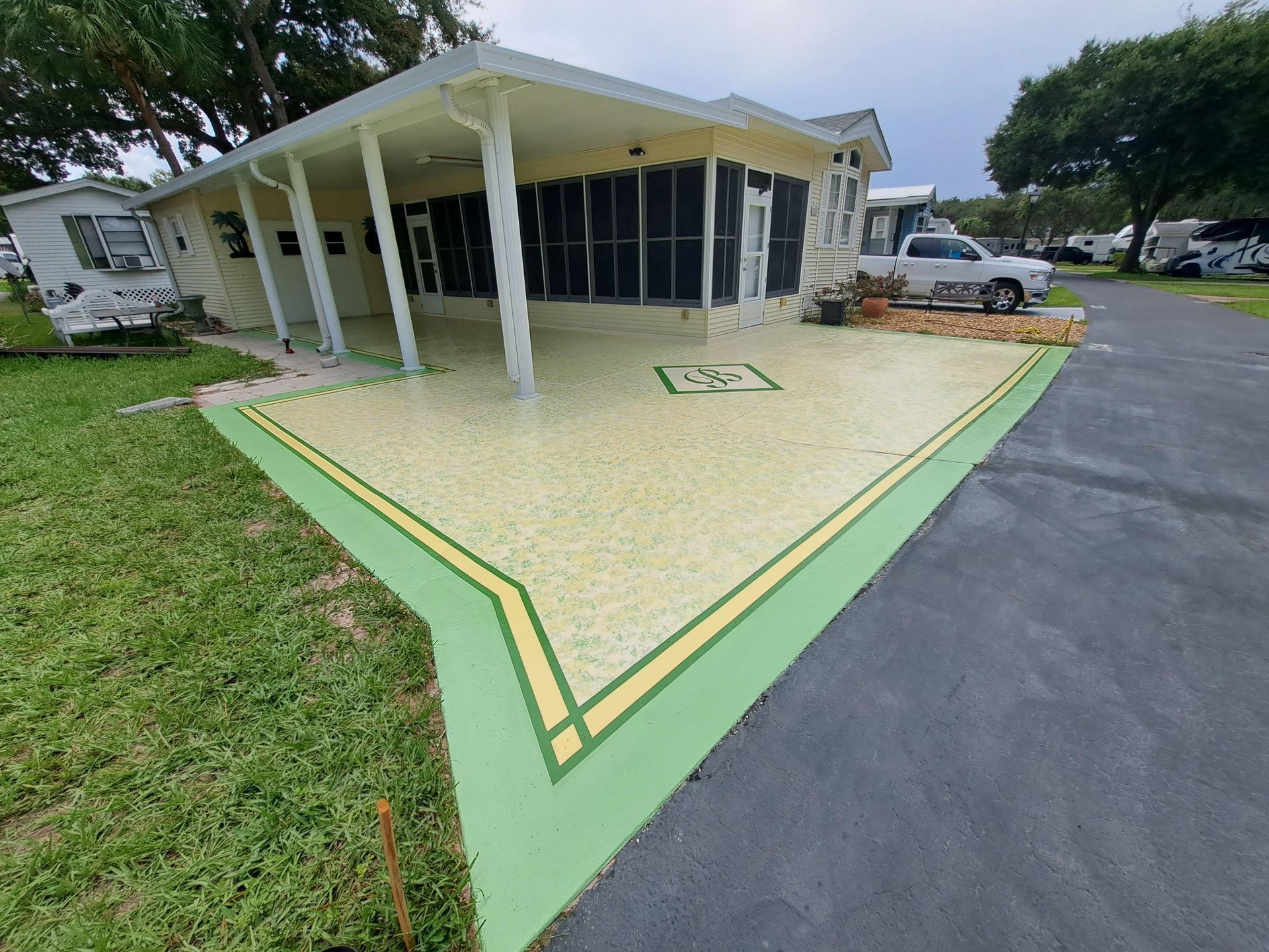 A mobile home with a green driveway in front of it.