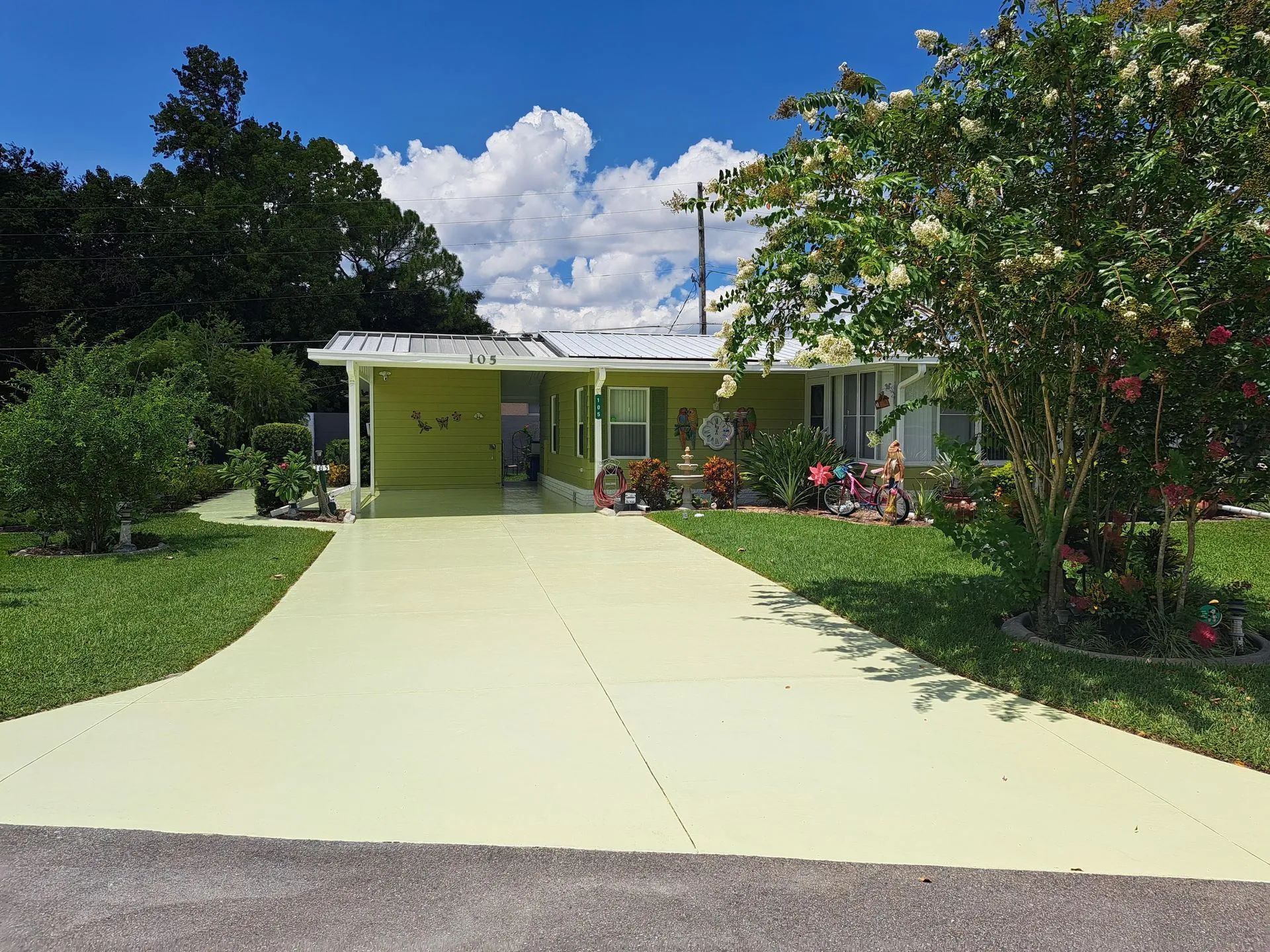 A yellow house with a driveway leading to it.