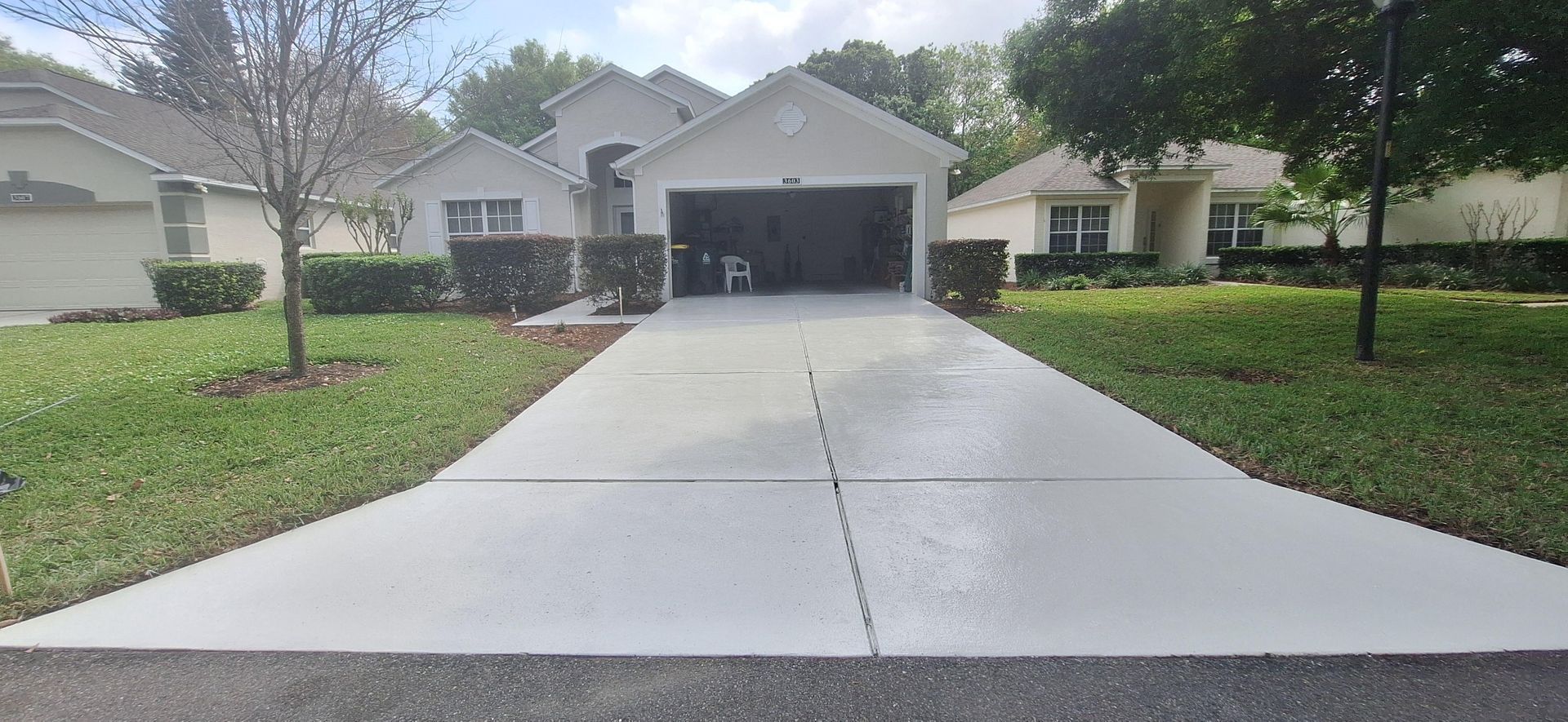 A concrete driveway leading to a house with a garage.