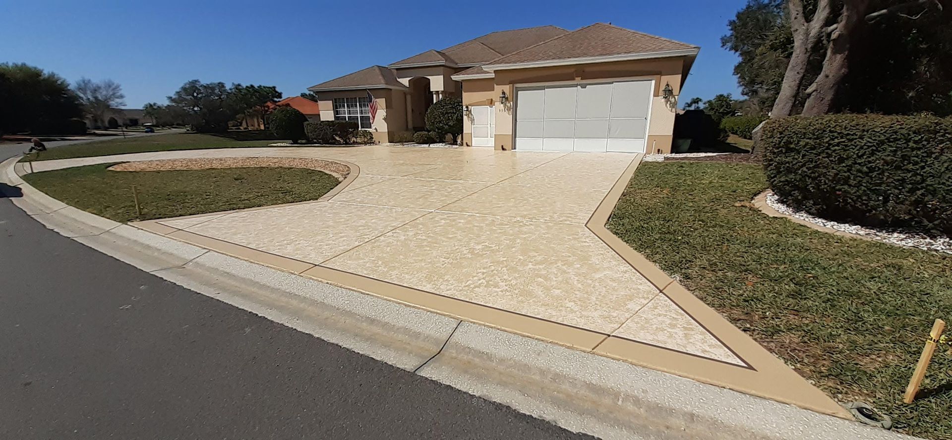 A driveway leading to a house with a large garage.