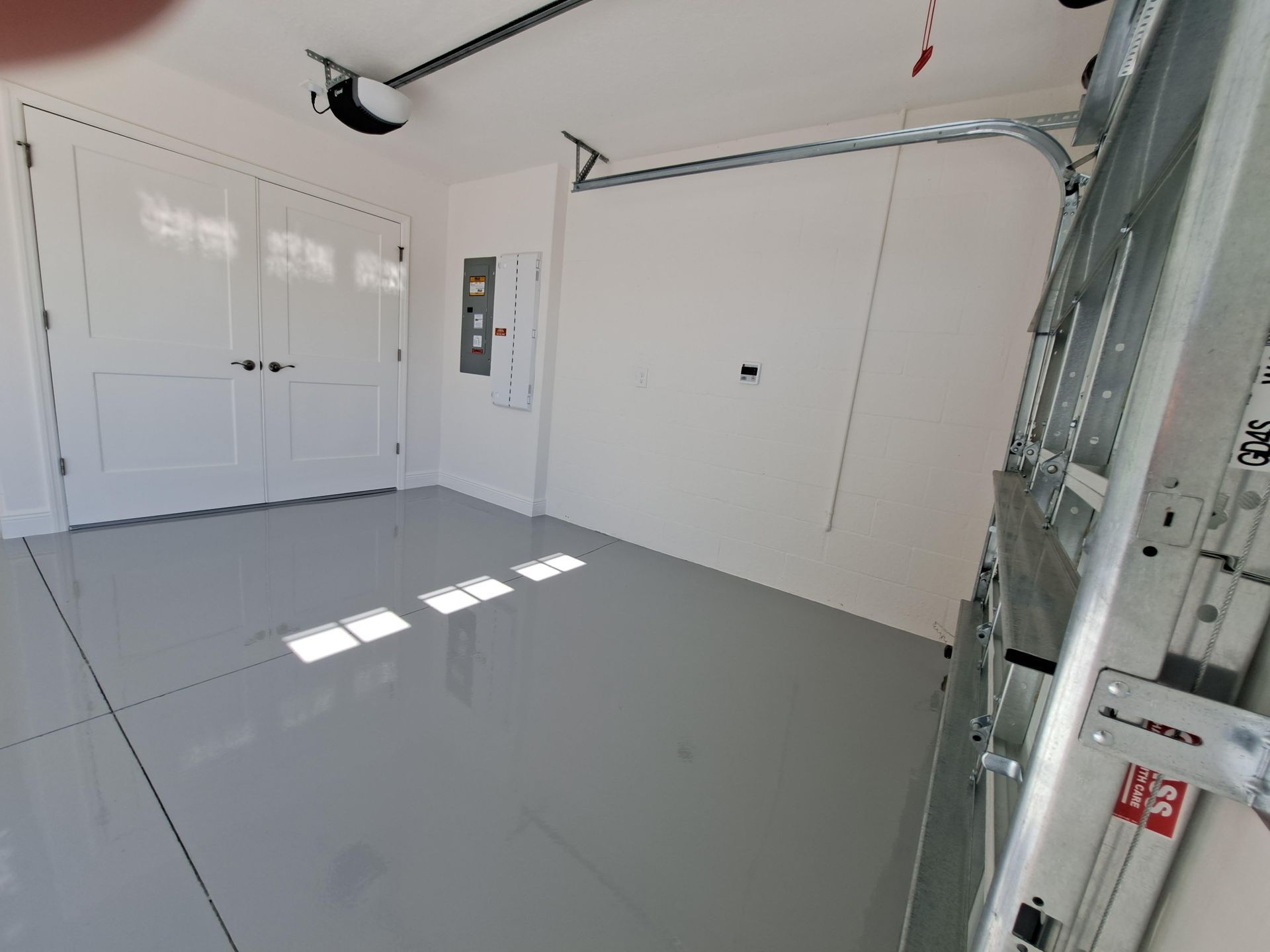 A garage with a garage door open and a ladder.