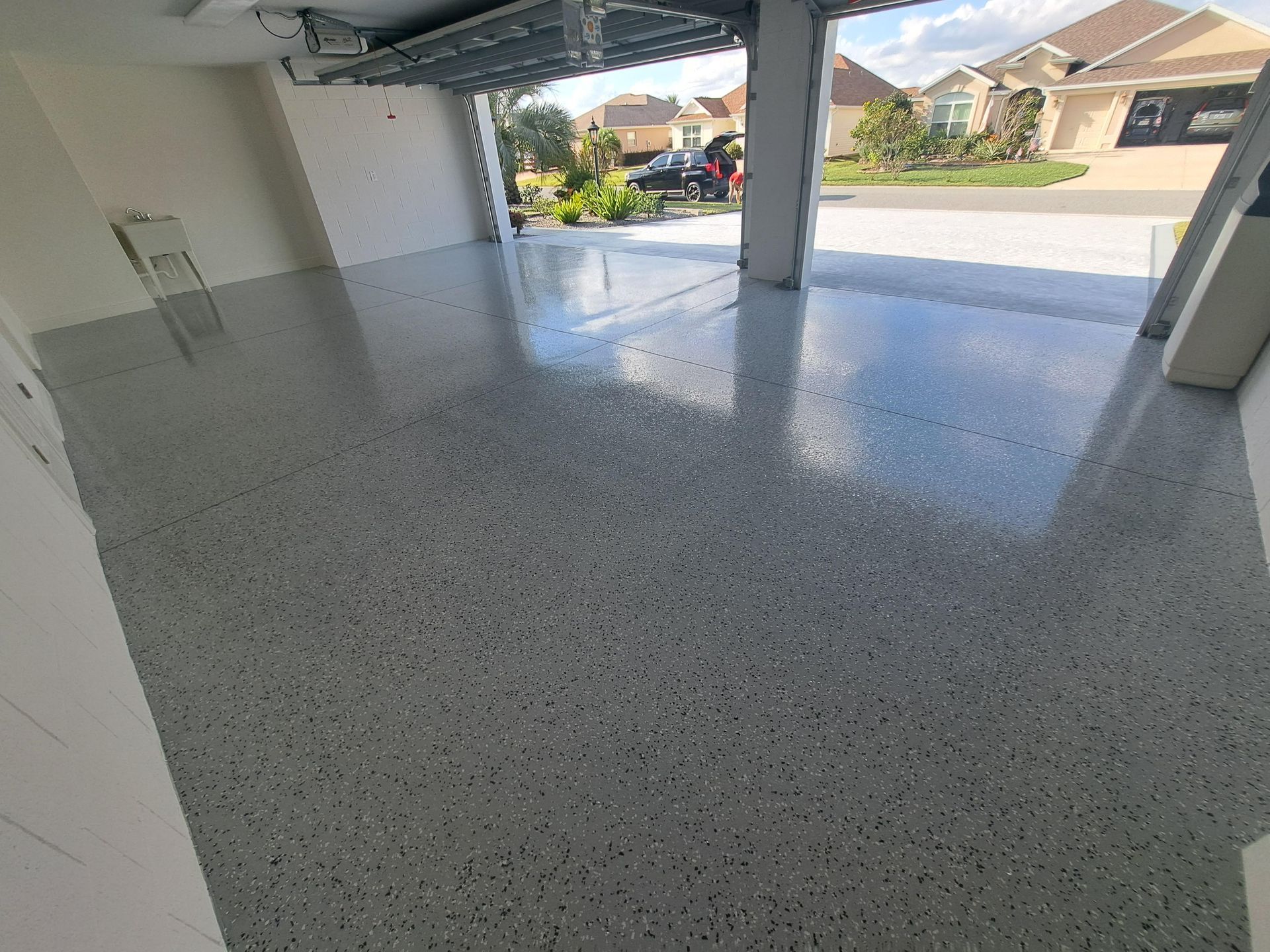 A garage with a concrete floor and a car parked in it.