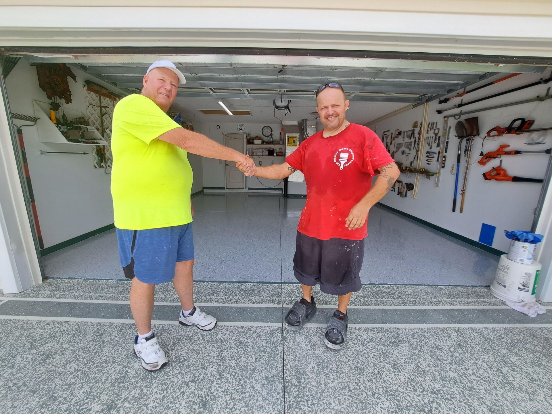 Two men are shaking hands in a garage.
