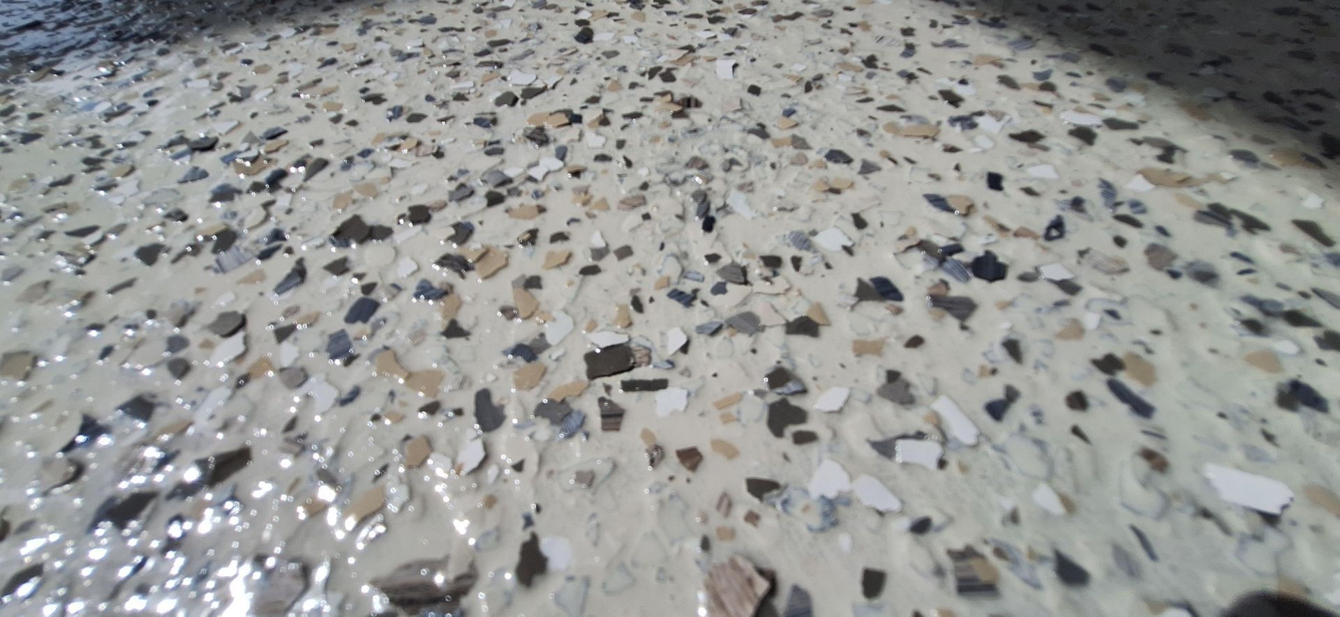 A close up of a concrete floor with a lot of small rocks on it.