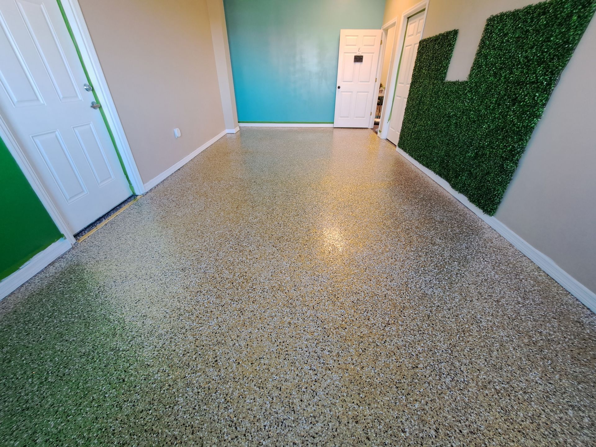 A hallway with a green wall and a green door.